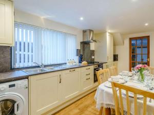 a kitchen with a table with a washing machine at 3 Bed in Keswick oc-86613 in Threlkeld