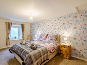 a bedroom with a bed with a flowery wallpaper at 3 Bed in Keswick oc-86613 in Threlkeld