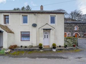 a stone house with a white door and potted plants at 3 Bed in Keswick oc-86613 in Threlkeld