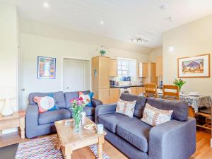 a living room with two blue couches and a table at 2 Bed in Dingwall oc-ca387 in Cononbridge
