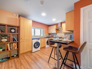 a kitchen with orange walls and a washer and dryer at 2 Bed in Bonnybridge oc-95833 in Bonnybridge