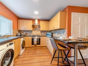 a kitchen with orange walls and a table with chairs at 2 Bed in Bonnybridge oc-95833 in Bonnybridge