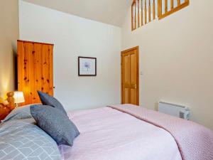 a bedroom with a large bed with blue pillows at 1 Bed in Beauly oc-82778 in Beauly