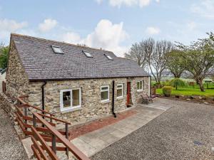 a stone cottage with a wooden fence in front of it at 1 Bed in Beauly oc-82778 in Beauly