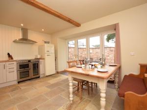 a kitchen with a wooden table with chairs and a table sidx sidx sidx at 2 Bed in West Linton oc-76383 in West Linton