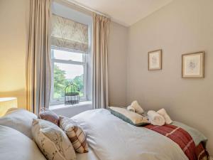 a bedroom with a bed with pillows and a window at 2 Bed in Ambleside oc-93287 in Near Sawrey