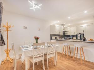 a white kitchen with a white table and chairs at 3 Bed in Keswick oc-sz217 in Threlkeld