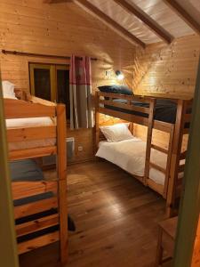 a bedroom with two bunk beds in a cabin at Le ptit Sabot in Corcieux