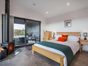 a bedroom with a bed and a wood stove at 1 Bed in Ardgay oc-90470 in Bonar Bridge