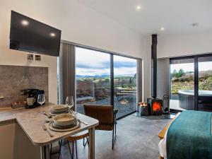 a kitchen and living room with a table and a fireplace at 1 Bed in Ardgay oc-90470 in Bonar Bridge