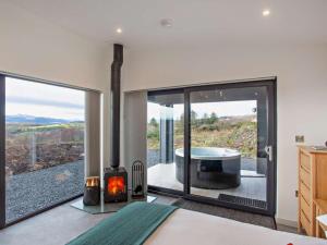 a bedroom with a fireplace and a view of a tub at 1 Bed in Ardgay oc-90470 in Bonar Bridge