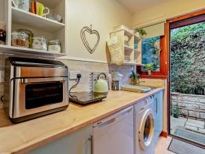 a kitchen with a counter top with a microwave at 1 Bed in Dollar oc-95872 in Powmill