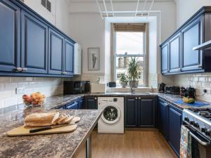 a kitchen with blue cabinets and a washer and dryer at 5 Bed in Melrose oc-79418 in Melrose