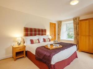 a bedroom with a large bed with a tray on it at 6 Bed in Ullapool oc-ca259 in Ullapool