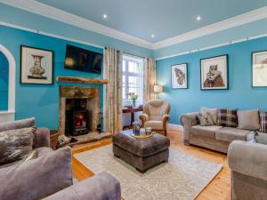 a living room with blue walls and a fireplace at 5 Bed in Anstruther oc-83504 in Pittenweem