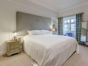 a bedroom with a large white bed and a window at 5 Bed in Anstruther oc-83504 in Pittenweem