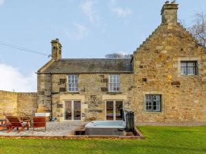 an old stone house with a grill in front of it at 5 Bed in Anstruther oc-83504 in Pittenweem