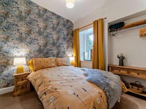 a bedroom with a bed with a floral wallpaper at 2 Bed in Maybole oc-96012 in Maybole