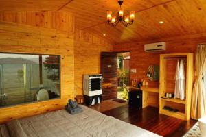 a bedroom with a bed in a wooden room at The Lake Hill Farm Tà Đùng in Biđong