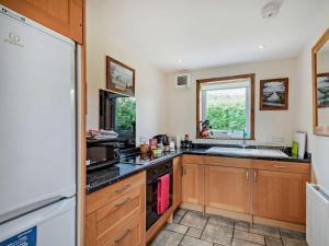a kitchen with wooden cabinets and a sink at 1 Bed in Castle Douglas oc-ca371 in Castle Douglas