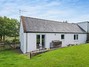 a white cottage with a picnic table and a grill at 1 Bed in Castle Douglas oc-ca371 in Castle Douglas