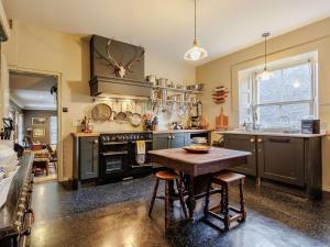 a kitchen with a wooden table and a stove at 5 Bed in Dunkeld oc-90844 in Birnam