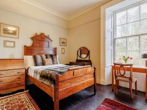 a bedroom with a bed and a dresser and a window at 5 Bed in Dunkeld oc-90844 in Birnam