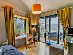 a bedroom with a large window with a view of a balcony at 3 Bed in Pitlochry oc-ca207 in Struan