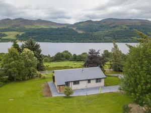 an aerial view of a house with a lake at 3 Bed in Pitlochry oc-ca207 in Struan