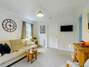 a living room with a couch and a clock on the wall at 1 Bed in Maybole oc-93562 in Maybole