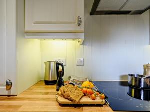 a kitchen counter with a cutting board with fruit on it at 1 Bed in Maybole oc-93562 in Maybole +9 photos