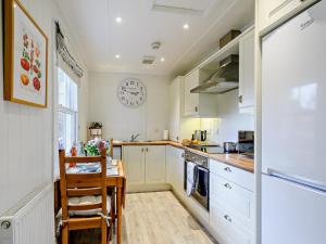 a kitchen with a table and a clock on the wall at 1 Bed in Maybole oc-93562 in Maybole