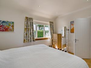 a bedroom with a white bed and a window at 3 Bed in Anstruther oc-96111 in Pittenweem +25 photos