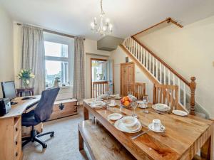 a dining room with a wooden table and a desk at 2 Bed in Millom oc-93608 in Millom