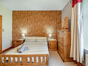 a bedroom with a bed and a wooden wall at 2 Bed in Millom oc-93608 in Millom