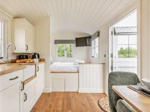 a kitchen with white cabinets and a bed in a room at 1 Bed in Forfar oc-92331 in Kingsmuir