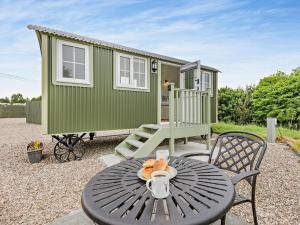 a green tiny house with a table and chairs at 1 Bed in Forfar oc-92331 in Kingsmuir +10 photos