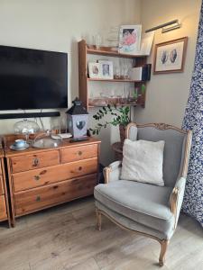 a living room with a chair and a television at Family Home FeWo de lux Świnoujście in Świnoujście