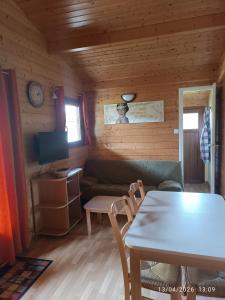 a living room with a couch and a table at La Taillade de Montségur location de Chalets en bois in Fougax-et-Barrineuf