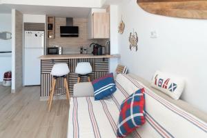 a living room with a couch and a kitchen at Cullera Playa Racó in Cullera