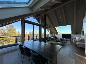 a living room with a large wooden table and chairs at Naava Chalet 402 Penthouse - Kattohuoneisto järvinäköalalla in Ähtäri