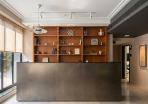 a reception desk in a room with a book shelf at Wellesley Hotel in Pune