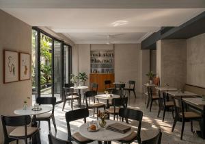 a restaurant with tables and chairs in a room at Wellesley Hotel in Pune +38 photos
