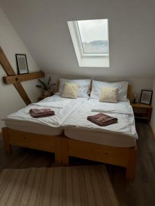 a bedroom with a bed with white sheets and a window at Resort Hvozd in Krompach