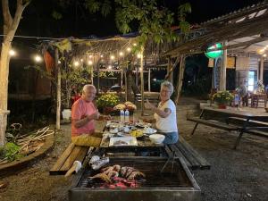 two people sitting at a table with a grill at An Yen Resort in Phú Quốc