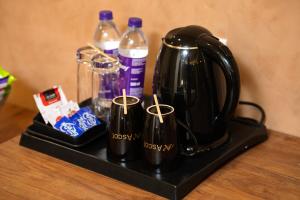 a black tea kettle and two bottles of water at Ascot Hotel in Kozhikode +27 photos