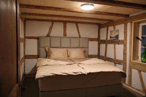 a small bed in a room with wooden beams at Ferienwohnung Obstgarten in Märstetten
