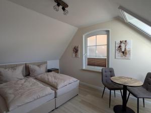 a bedroom with a bed and a table and chairs at Landhaus Freche Socke in Buchhorst