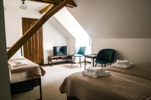a attic room with two beds and a television at Viešbutis DYVAI in Kupiškis