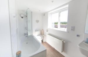 a white bathroom with a shower and a toilet at 2 Bed in Upper Vobster oc-c39495 in Mells +7 photos